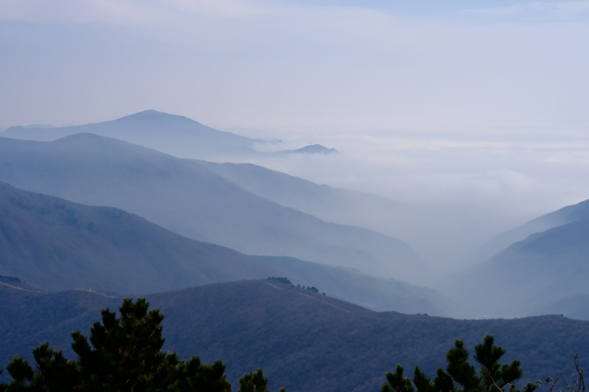 Layers of blue mountain ridges receding into pale mist